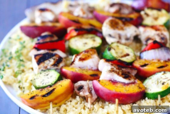Delicious grilled peach and chicken kabobs on a skewer, garnished with fresh herbs.