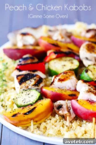 Served grilled peach and chicken kabobs on a platter with couscous, ready to eat.