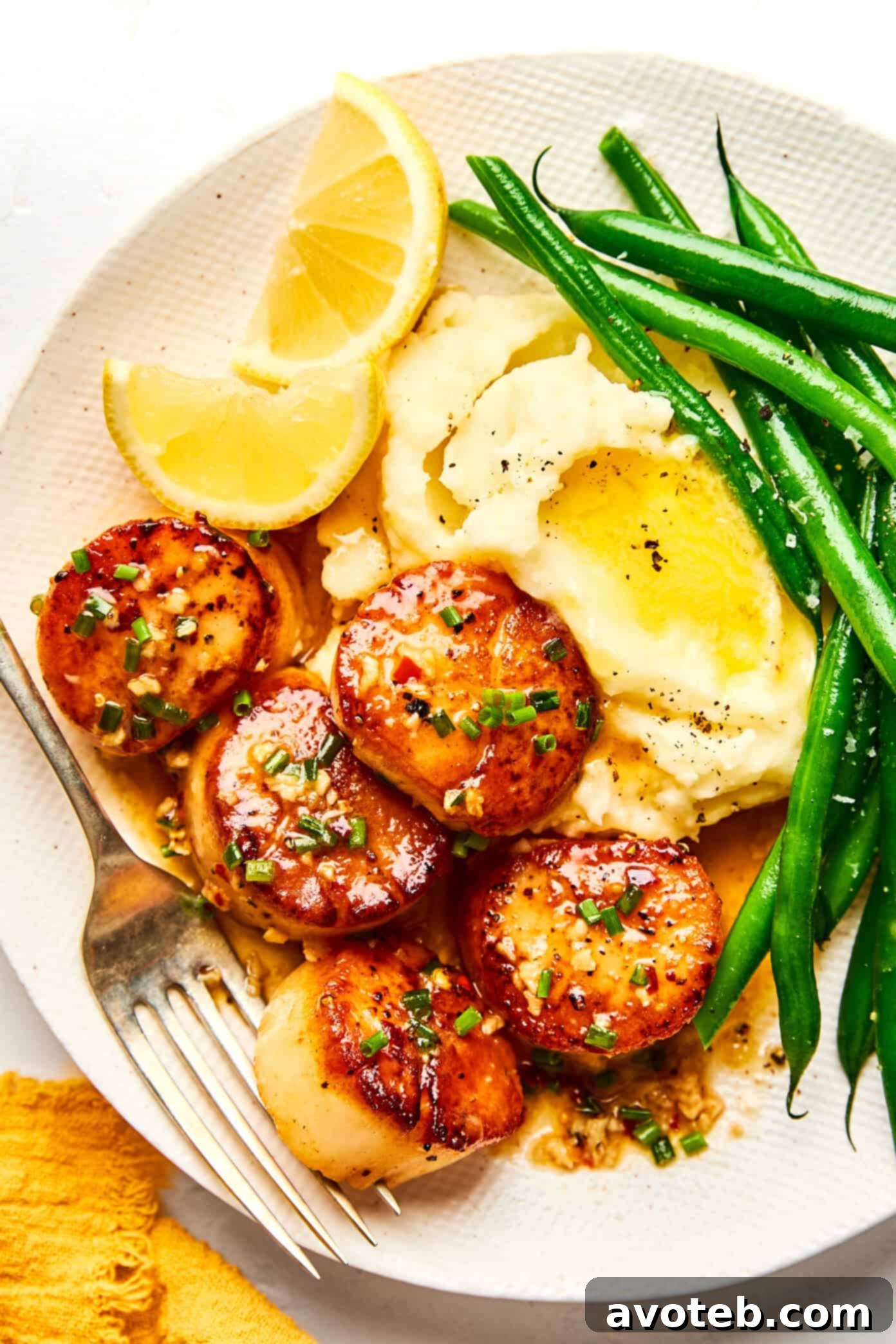 Lemon-Kissed Scallops with Garlic Butter Glaze 2 Seared scallops with lemon garlic butter, mashed potatoes, and green beans. A delicious and elegant meal.