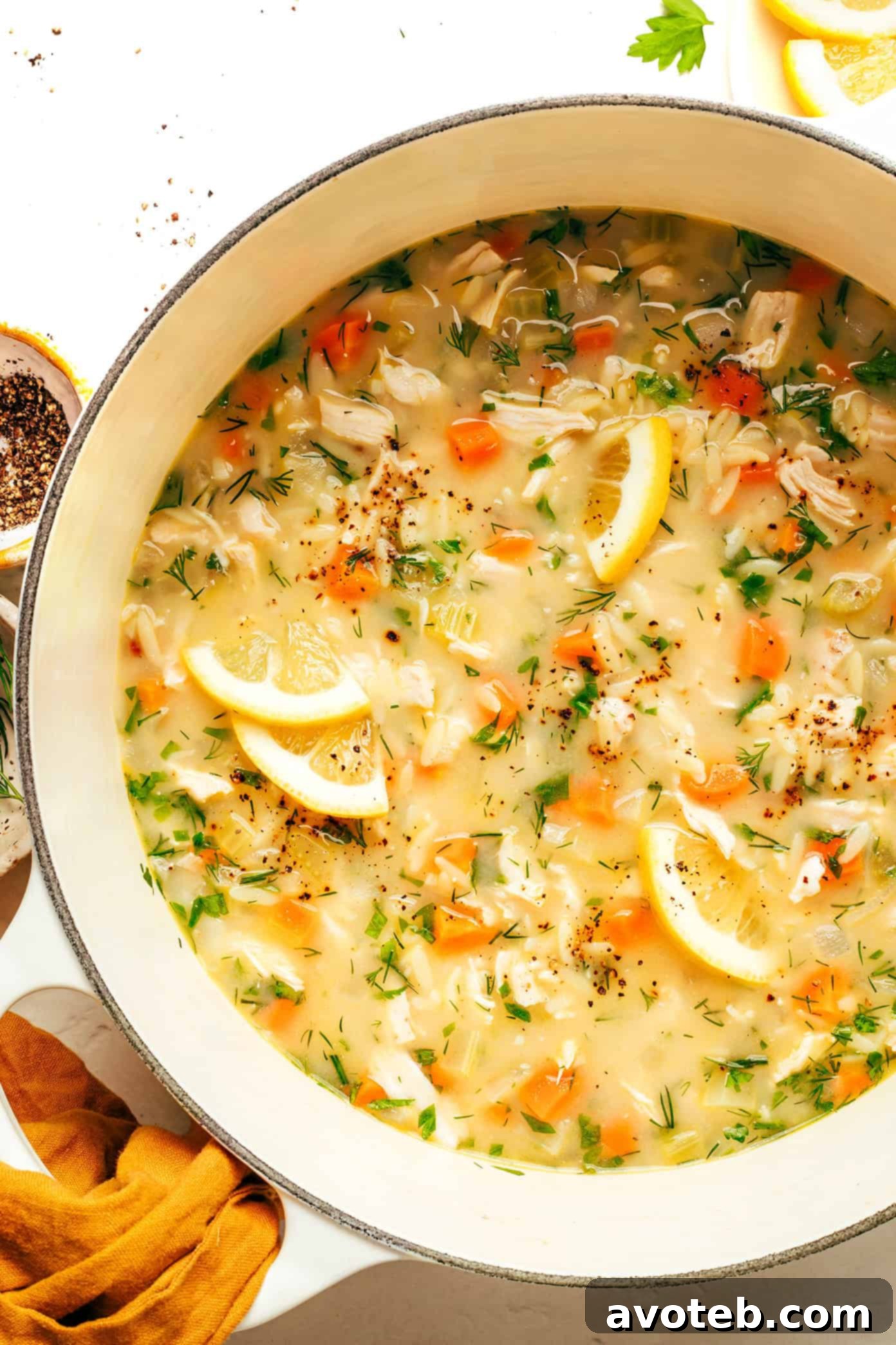 Bowl of Lemony Orzo Chicken Soup with a spoon
