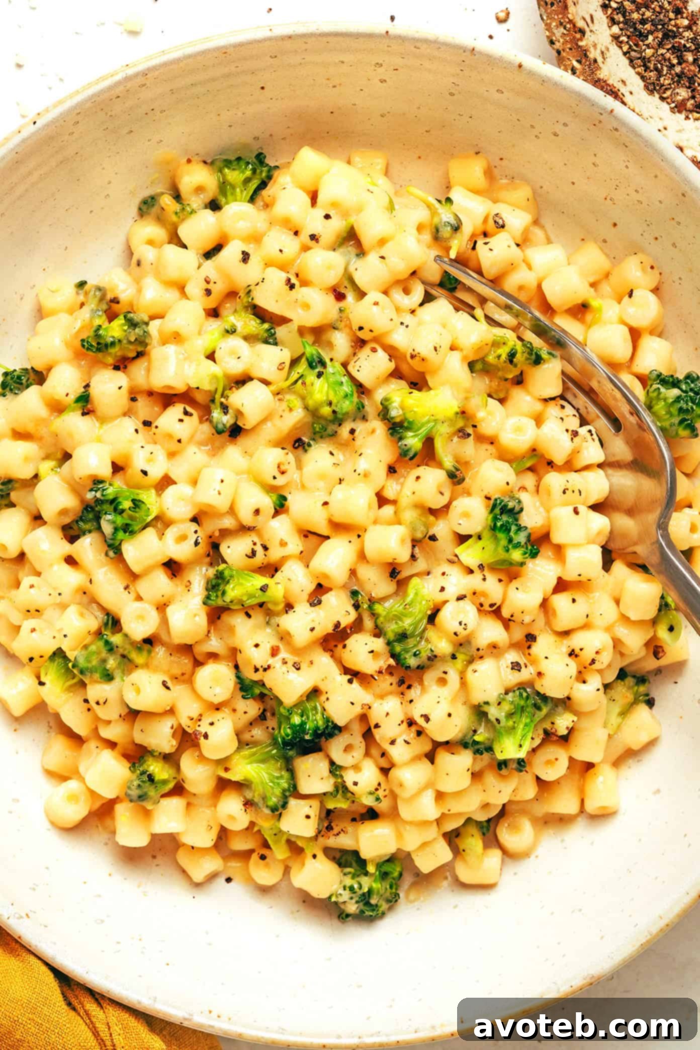 A generous serving of creamy broccoli pasta with a fork, ready to be enjoyed, showcasing the rich sauce and tender pasta.