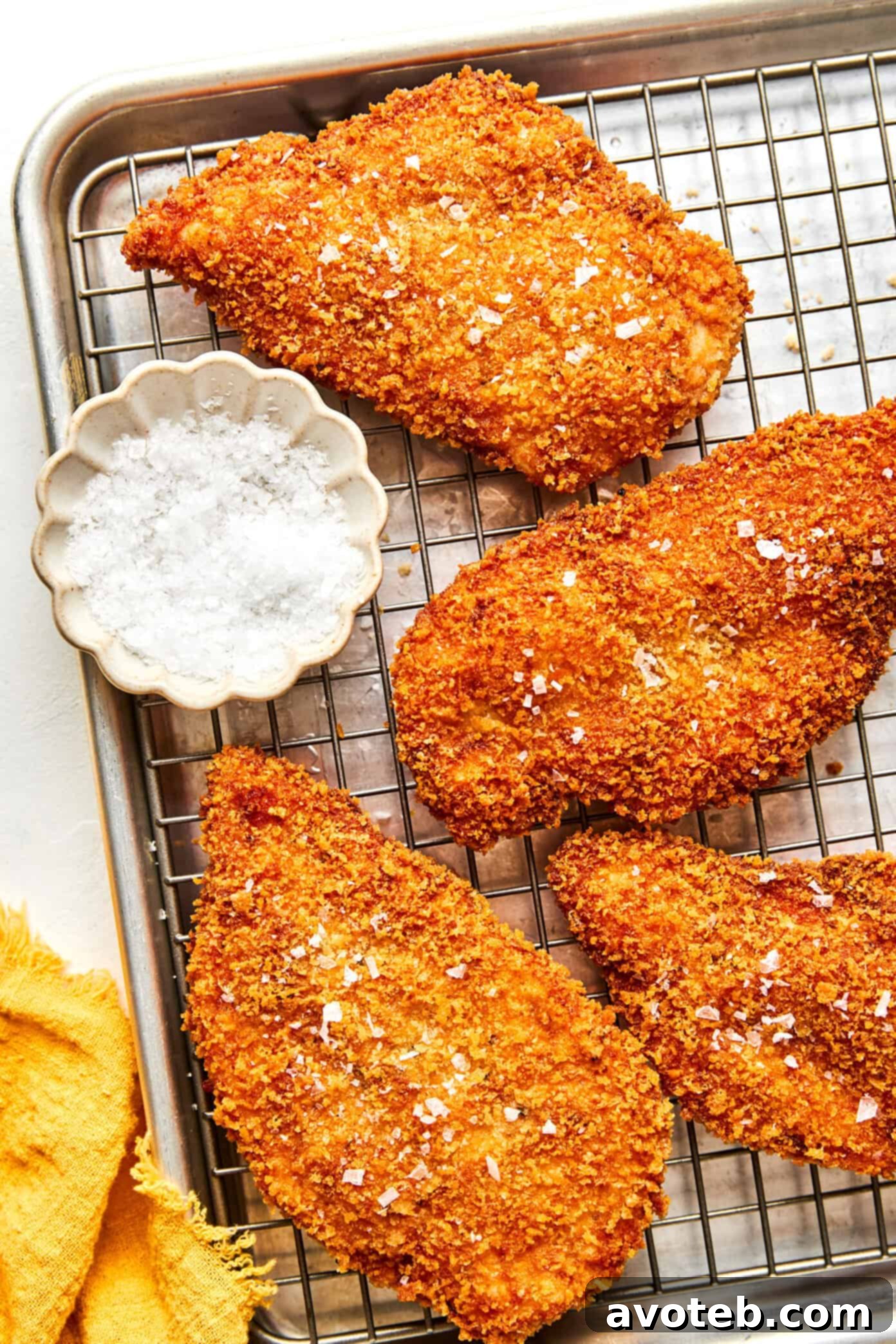 A serving of Crispy Chicken Milanese with lemon wedges, viewed from above, ready to be enjoyed.