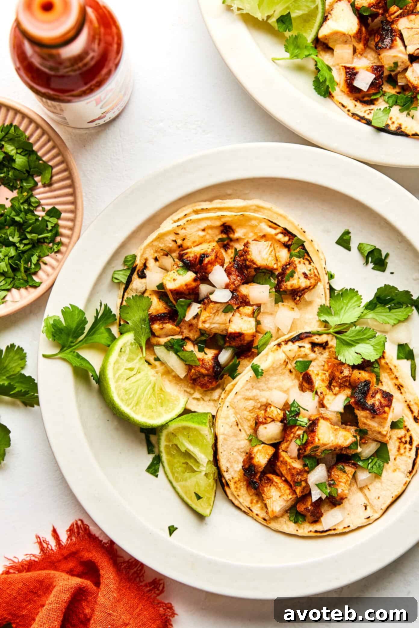 A close-up of several prepared Chipotle Chicken Tacos arranged on a rustic platter.