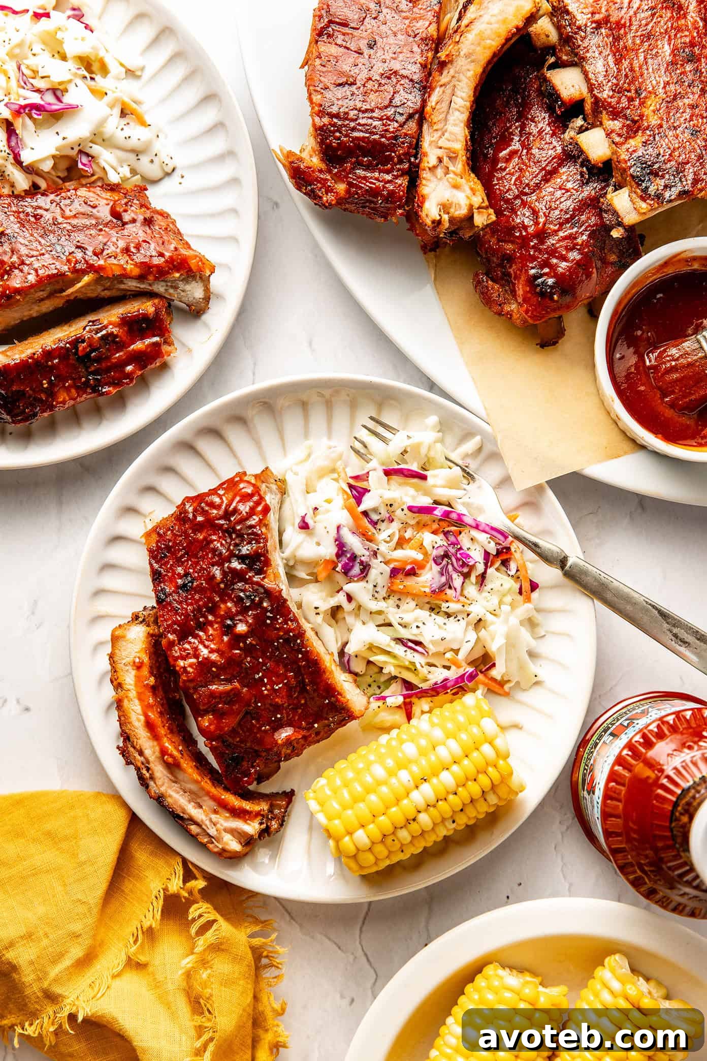 plate of baby back ribs with corn and coleslaw