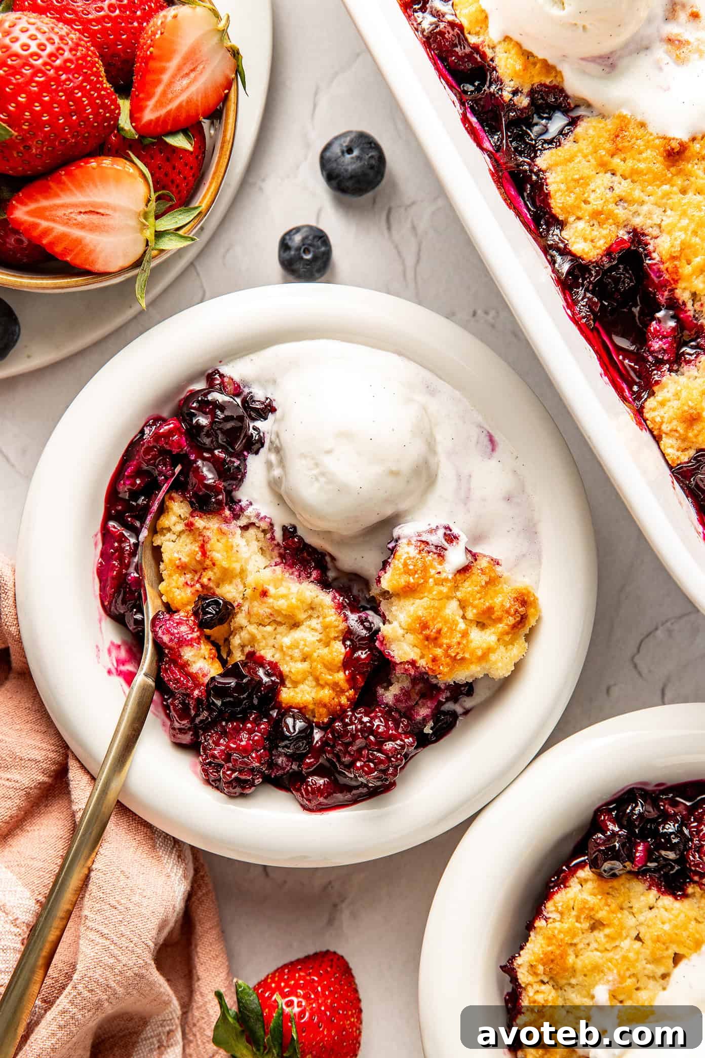 lemon berry cobbler in bowl with vanilla ice cream